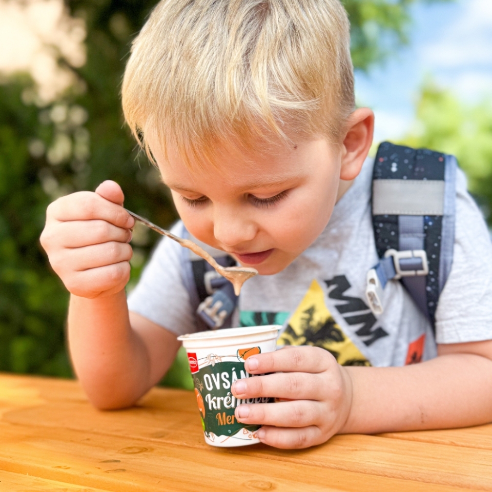 Chlapec na výletě jí lžící jogurt ovsánek